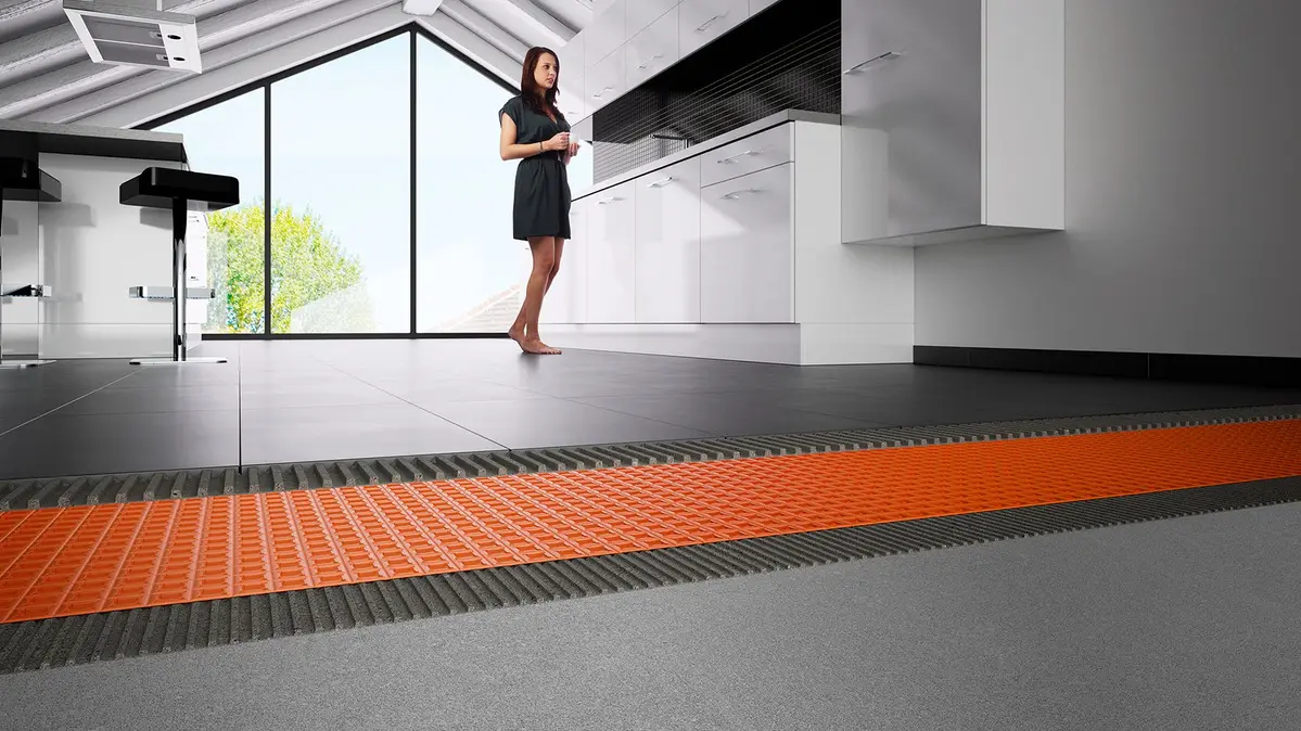 Moderne keuken met zwarte tegelvloer, vloerverwarming en oranje ontkoppelingsmat voor optimale warmtegeleiding