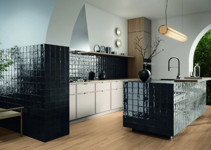 Moderne keuken met houtlook vloertegels en glanzende zwarte wandtegels rond kookeiland en werkblad